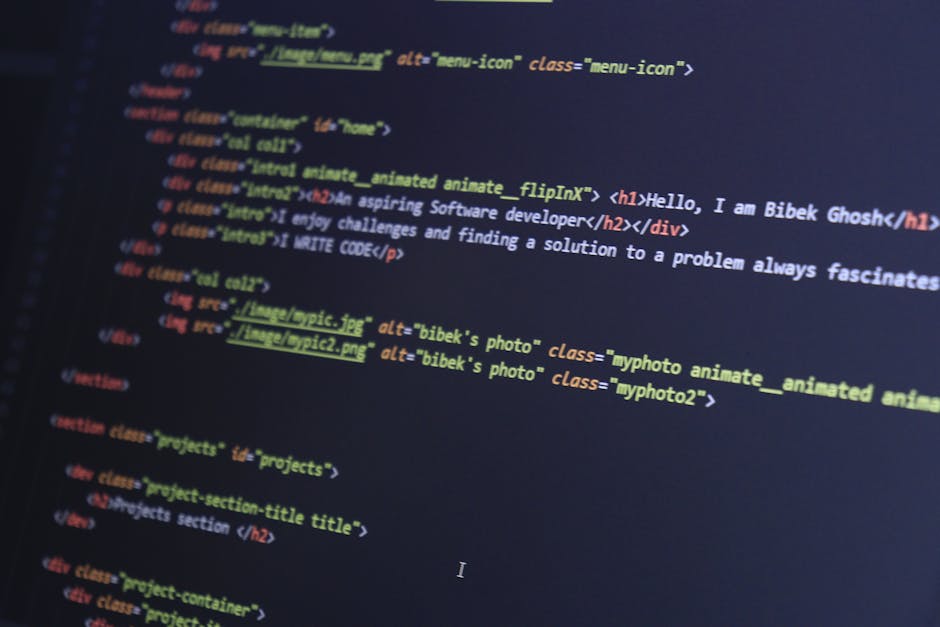 A close-up view of a laptop on a desk displaying a coding interface with XML code on the left side of the screen and a simple orange calculator interface on the right side. The coding editor shows lin